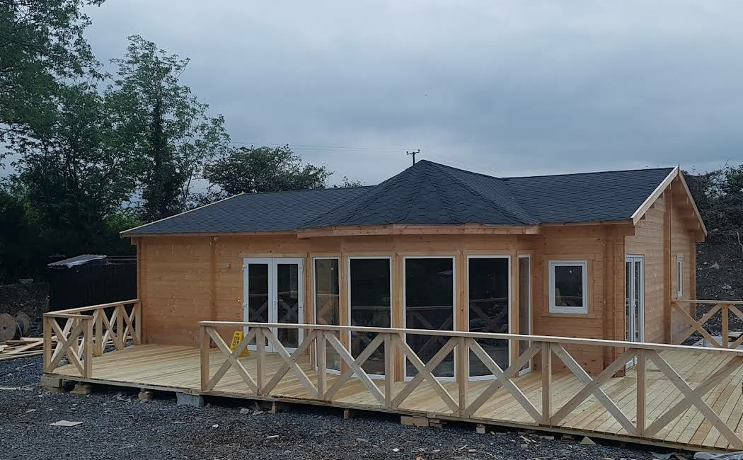 front of a log cabin under construction