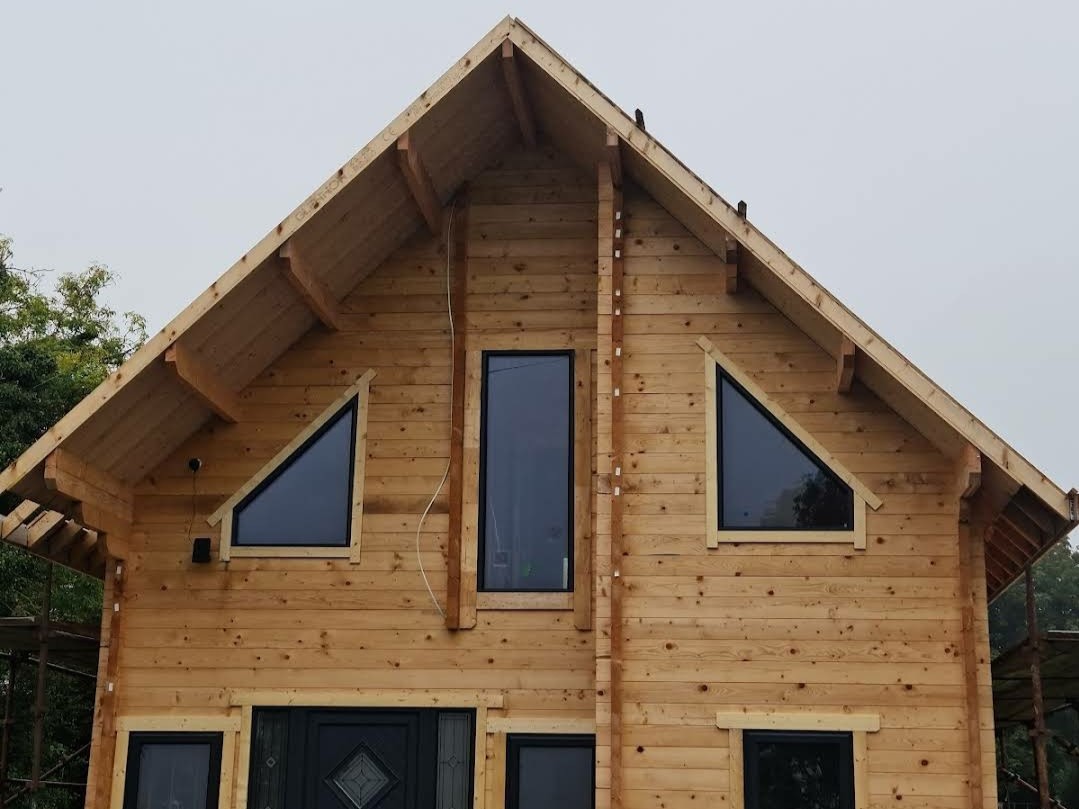 image of the front of a two storey log cabin in ireland